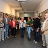 Uczestnicy wernisażu, w tle wystawa.