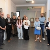 Uczestnicy wernisażu, w tle wystawa.