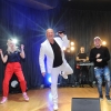 Artysta na scenie w towarzystwie kobiety i mężczyzny.