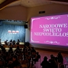 ludzie na sali i ekran na ścianie z napisem Narodowe Święto Niepodległości