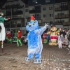 duża maskotka i szczudlarze podczas występu na placu