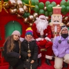 3 dziewczynki pozują do zdjęcia ze św. Mikołajem