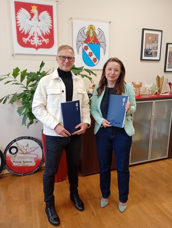 kobieta i mężczyzna pozują do zdjęcia z teczkami w rękach