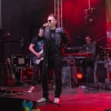 mężczyzna - wokalista śpiewa na scenie