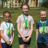 trzy dziewczynki z medalami pozują do zdjęcia