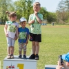 troje dzieci pozuje do zdjęcia na podium