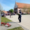 policjant składa wiązankę pod pomnikiem