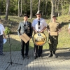 trzech mężczyzn pozuje do zdjęcia, jeden z tarczą