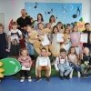 19. Na tle kolorowej scenografii wszyscy uczestnicy konkursu oraz jury pozują do zdjęcia
