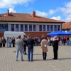 4 osoby stoją przed grupą dzieci i nauczycieli na boisku szkolnym
