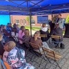 dzieci siedzą pod namiotem podczas warsztatów z prowadzącym