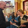 ks. Sławomir Jessa składa gratulacje i wręcza książkę dyrygentce chóru Annie Tilgi.