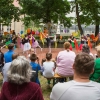 dziewczynki w kolorowych spódniczkach i z kolorowymi chustkami tańczą na scenie przed publicznością