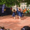 dziewczęta w niebieskich sukniach wynoszą do góry tancerkę na scenie