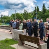 grupa ludzi stoi na peronie przy budynku dworca