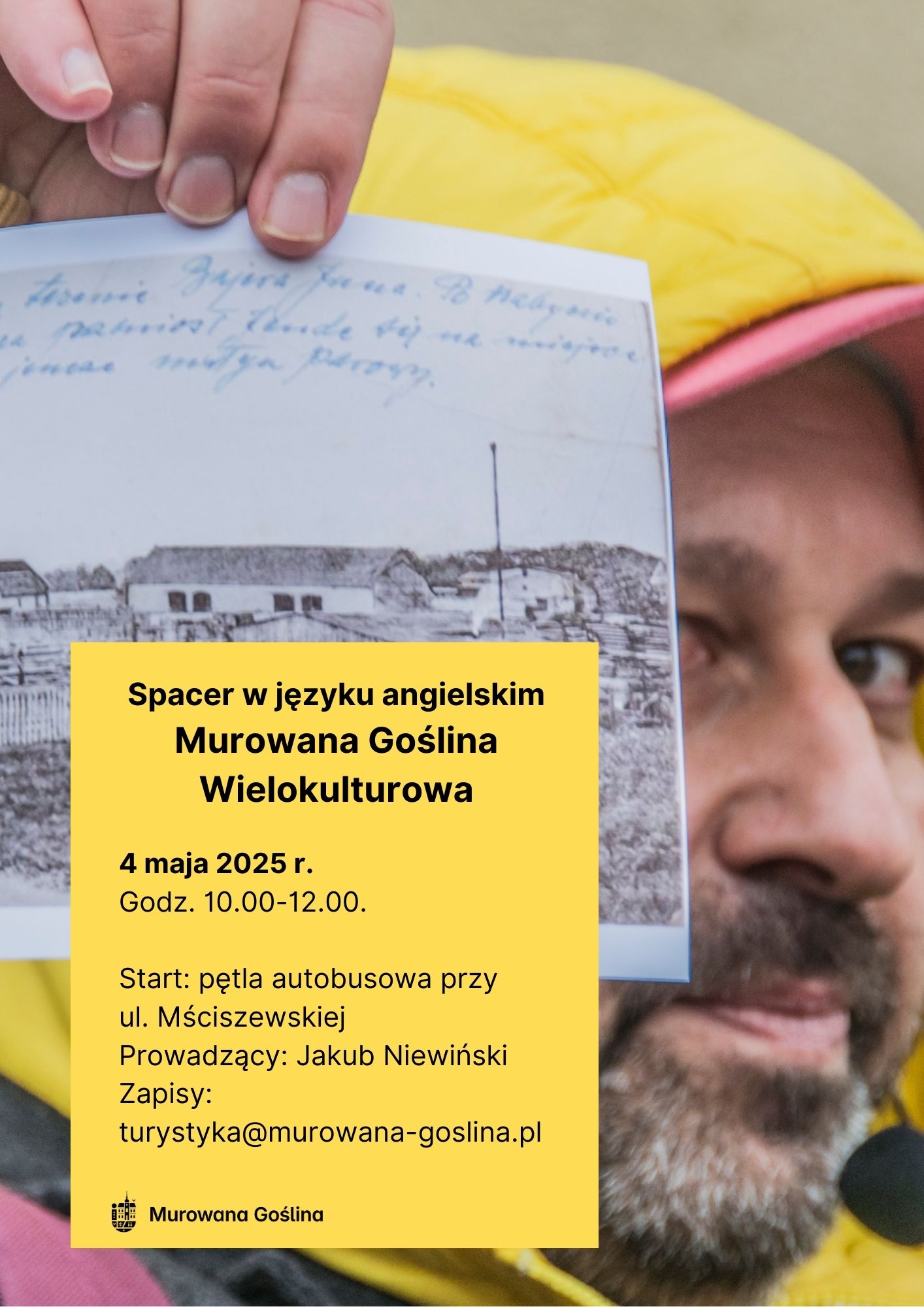 na plakacie mężczyzna pokazujący z bliska starą pocztówkę ze starymi zabudowaniami