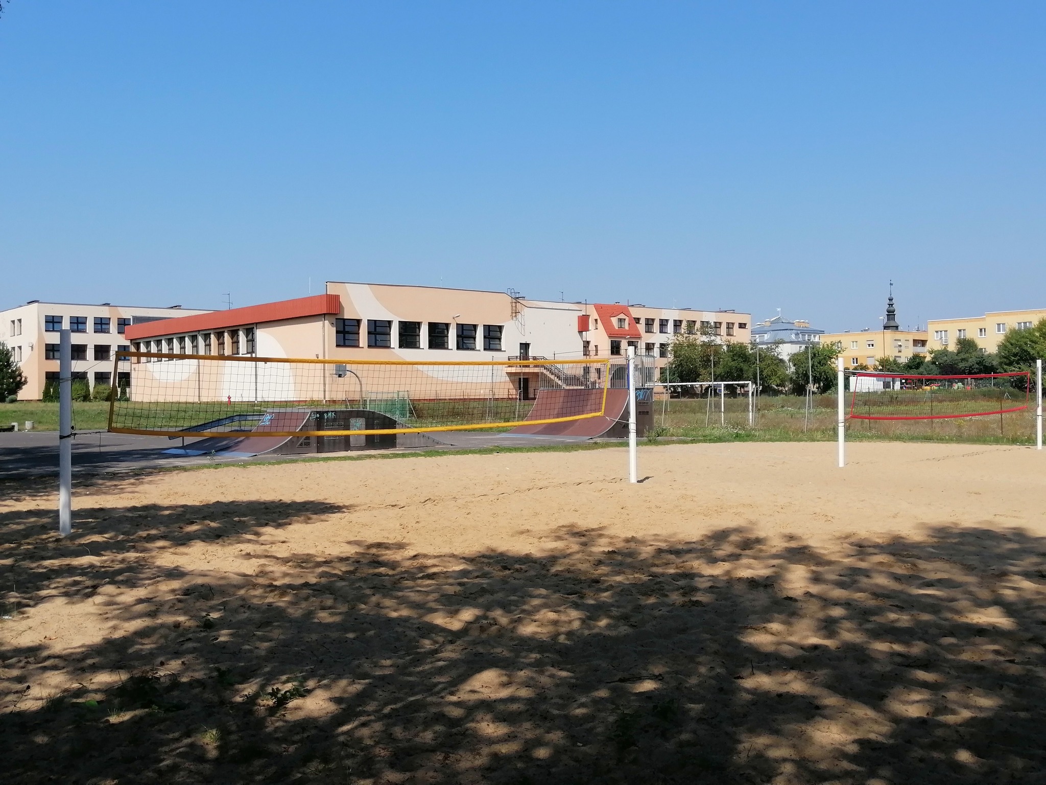 budynek szkoły z boiskiem do piłki siatkowej