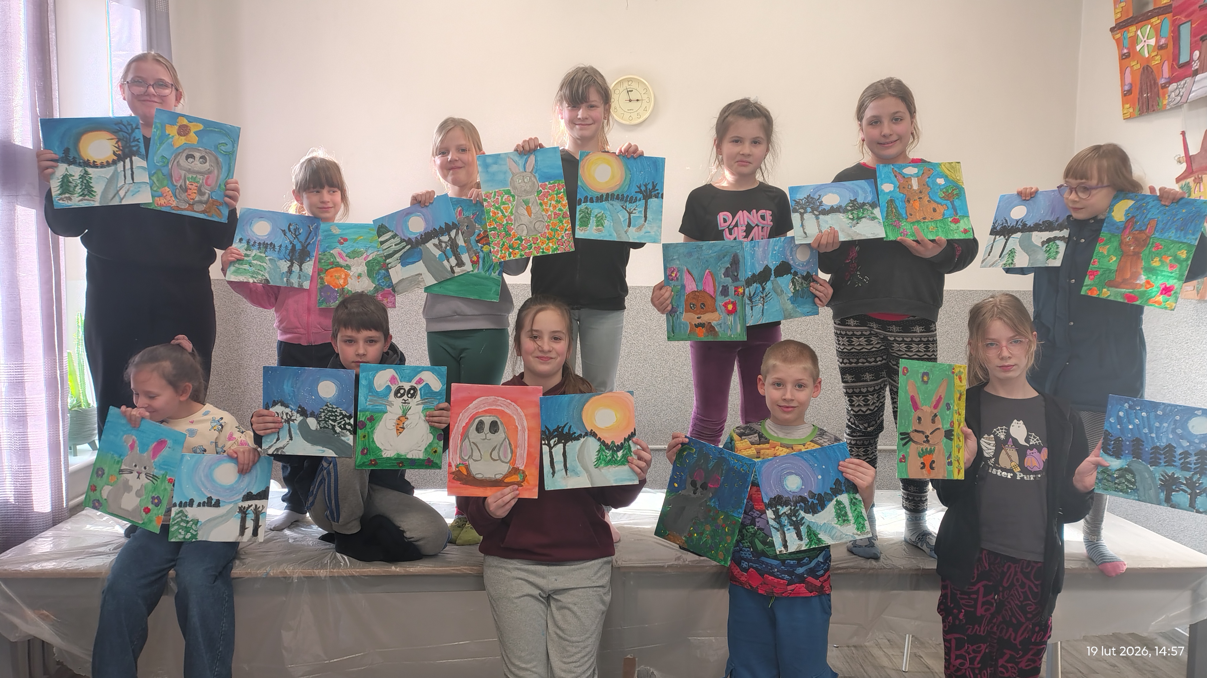 [obraz] Uczestnicy warsztatów pozują ze swoimi pracami.